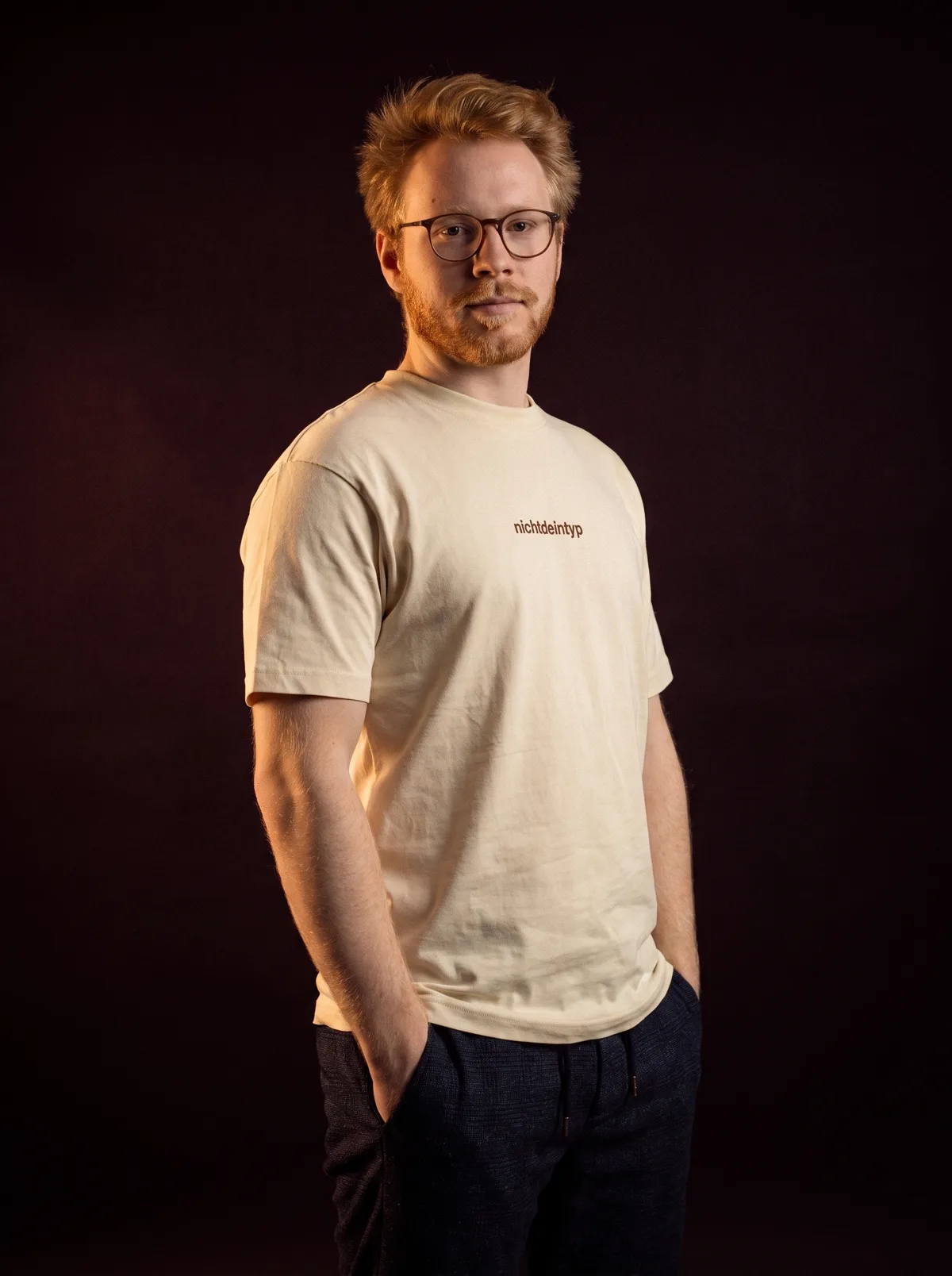 Model im beigen wolfskopf t-shirt im dunklen Studio